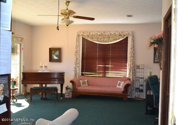 3943 Heath Road Jacksonville, FL 32277 - Photo 34 of 49 a bedroom with a bed and a chandelier