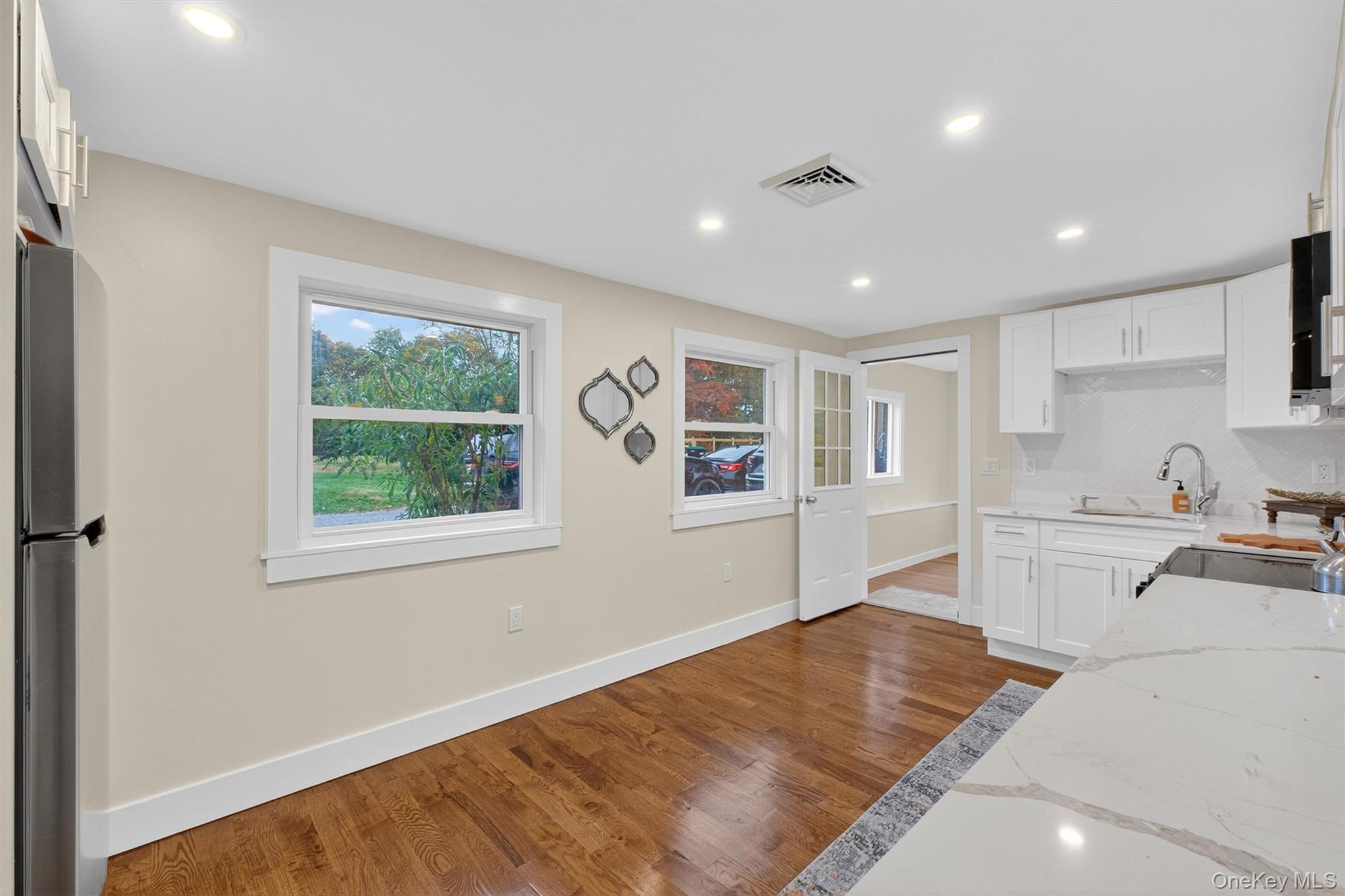 86 Vassar Road Poughkeepsie, NY 12603 - Photo 12 of 31 Kitchen featuring white cabinetry, light stone counters, dark wood finished floors, recessed lighting, and freestanding refrigerator