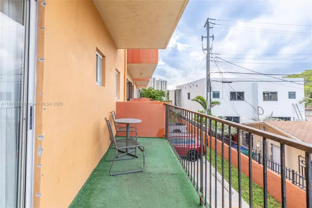 a balcony view with two chairs and a table