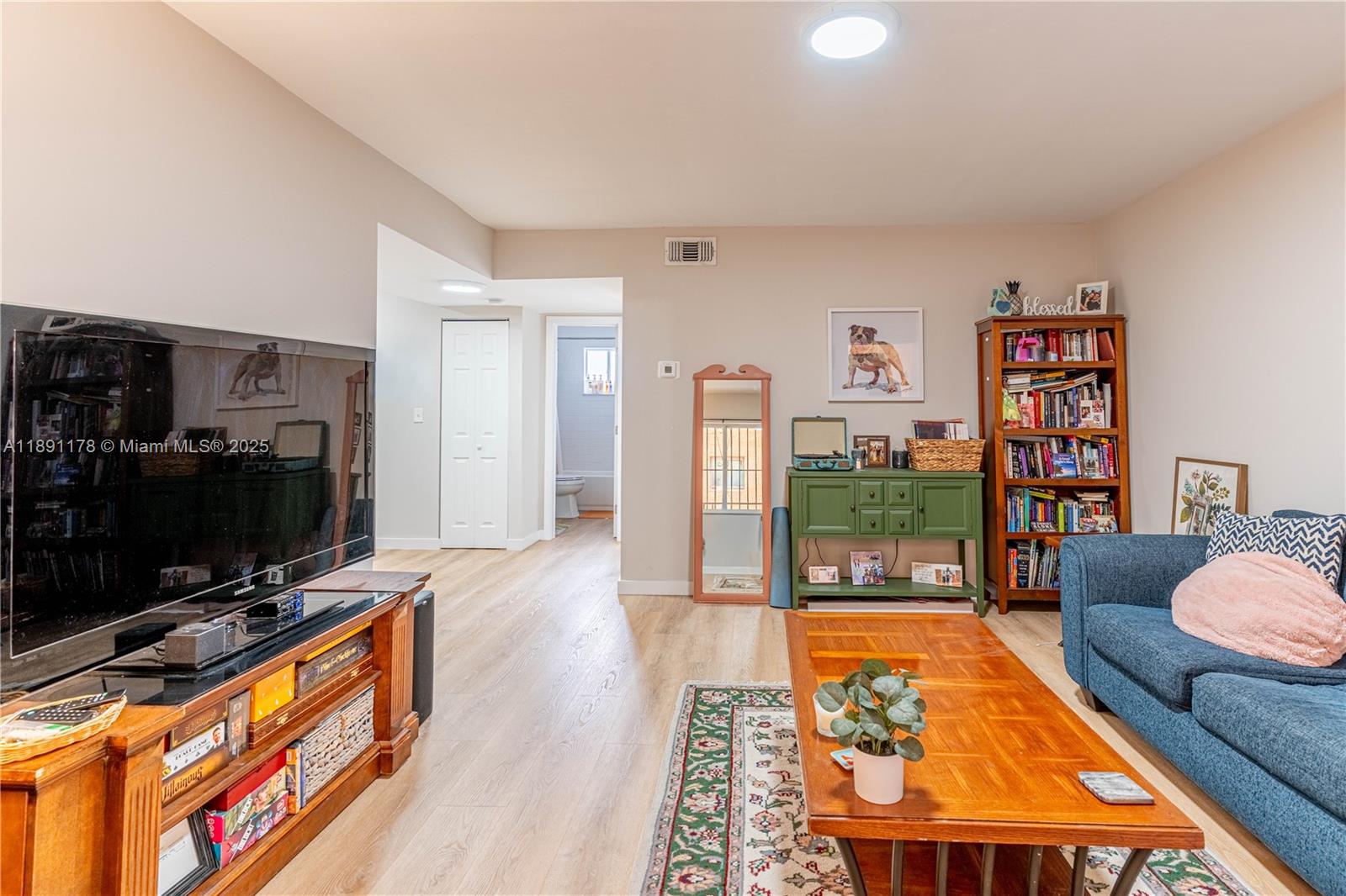 2921 Southwest 10th Street, Unit 26 Miami, FL 33135 - Photo 2 of 19 a living room with furniture a flat screen tv and a bookshelf