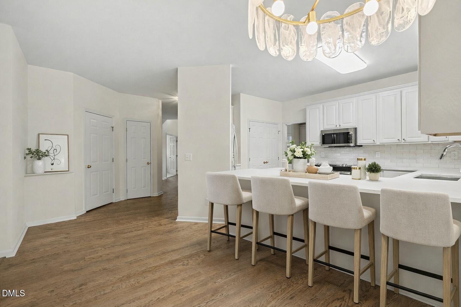 10415 Ashmead Lane Raleigh, NC 27614 - Photo 12 of 44 a kitchen with kitchen island granite countertop a sink cabinets and wooden floor