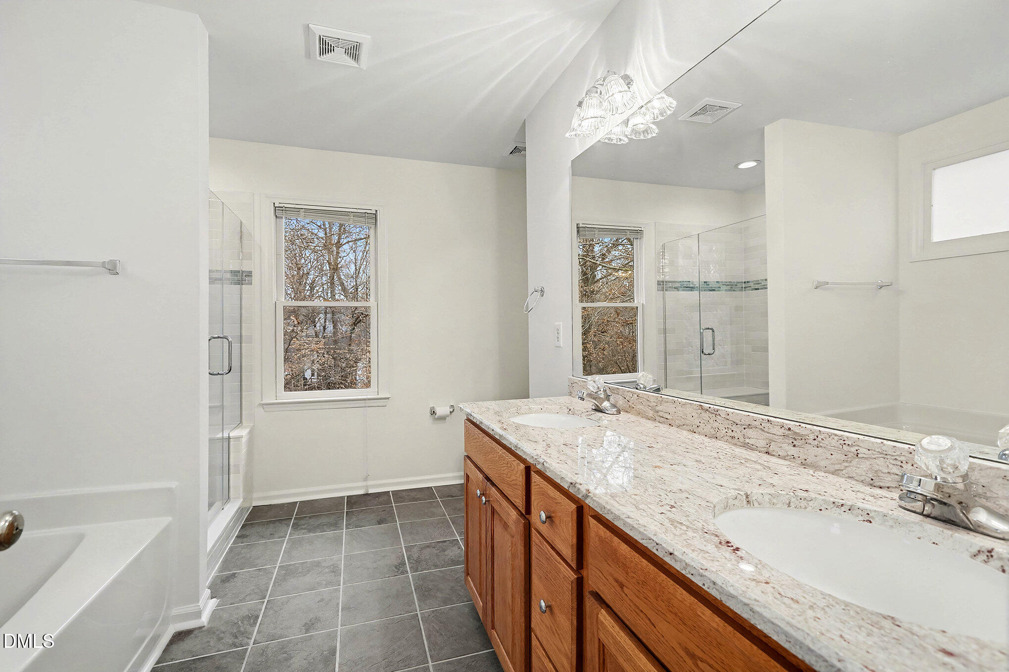 10415 Ashmead Lane Raleigh, NC 27614 - Photo 27 of 44 a bathroom with a granite countertop sink a large mirror and a bathtub
