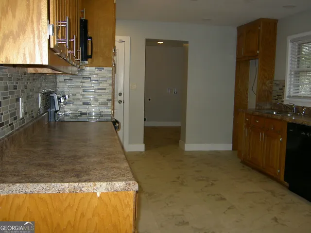 a kitchen with stainless steel appliances granite countertop a stove a sink and a refrigerator with wooden cabinets