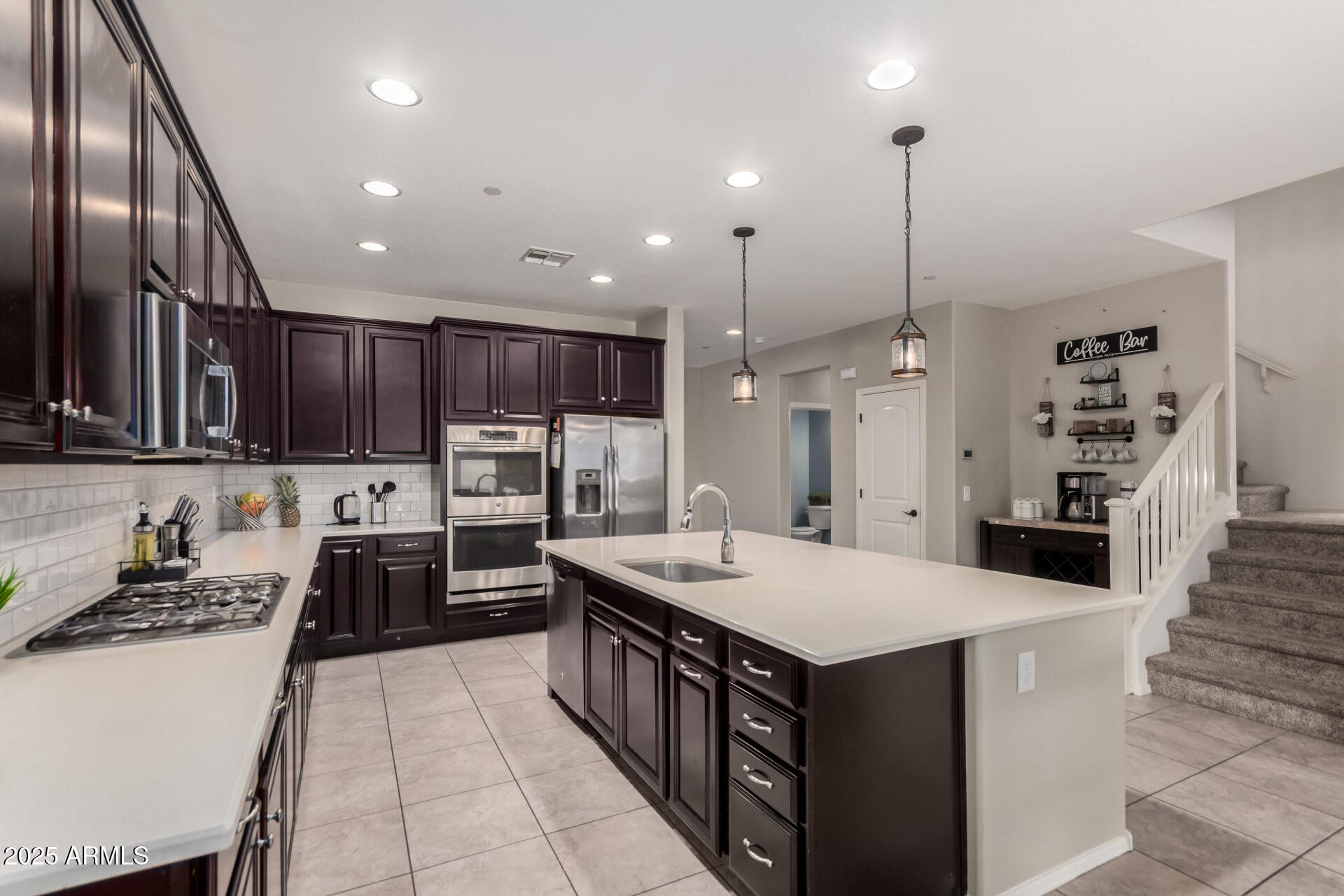 21243 West Coronado Road Buckeye, AZ 85396 - Photo 11 of 49 a kitchen with stainless steel appliances kitchen island granite countertop a sink and a refrigerator