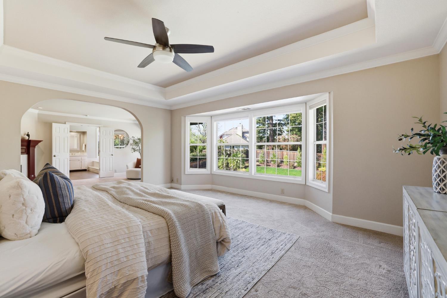 4330 Hale Ranch Lane Fair Oaks, CA 95628 - Photo 45 of 77 a spacious bedroom with a large bed and a chandelier fan