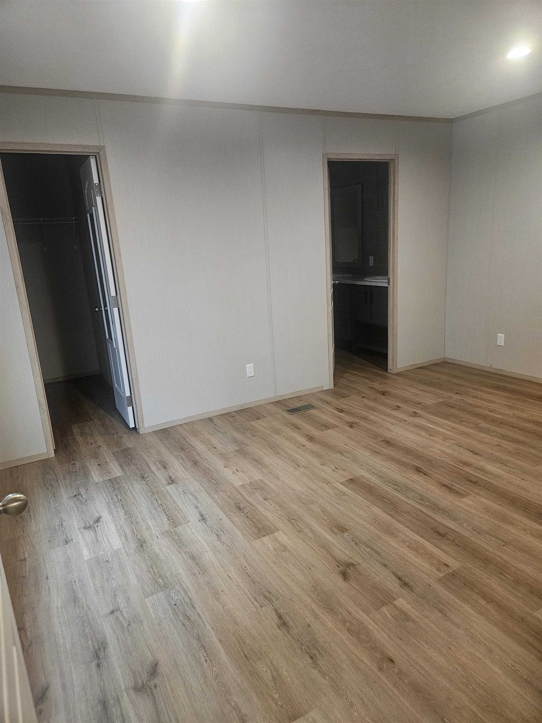 75 Pittman Road, Unit ROAD Somerville, TN 38068 - Photo 22 of 26 Spacious room featuring wood-finish flooring and light gray paneled walls