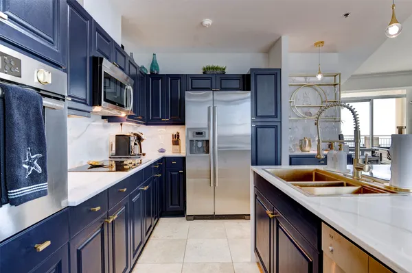 a kitchen with stainless steel appliances granite countertop a sink refrigerator and cabinets