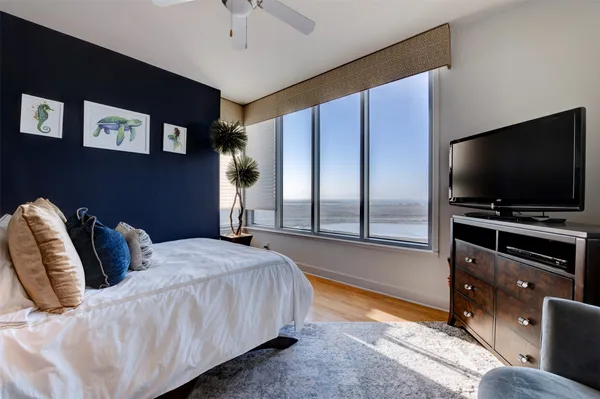 a spacious bedroom with a bed and a flat screen tv