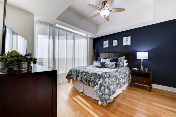 a bedroom with a large bed and a chandelier fan