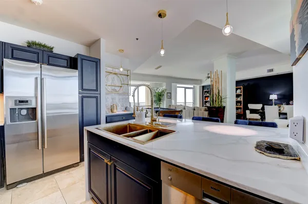 a kitchen with stainless steel appliances granite countertop a sink and a refrigerator
