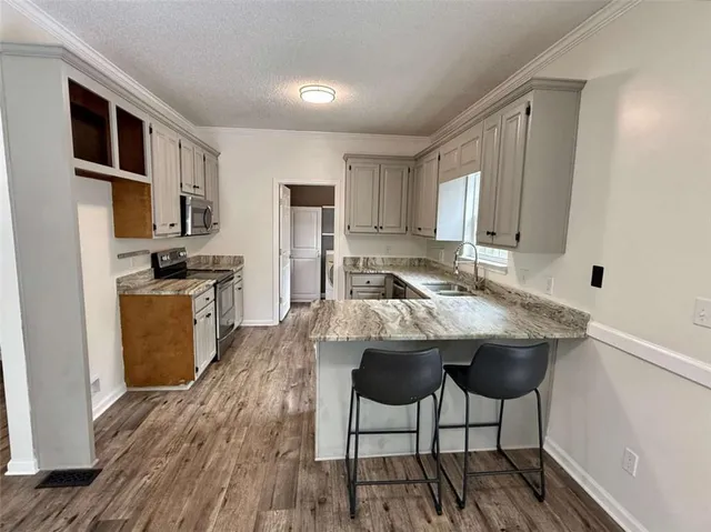 a kitchen with stainless steel appliances granite countertop a sink stove and cabinets
