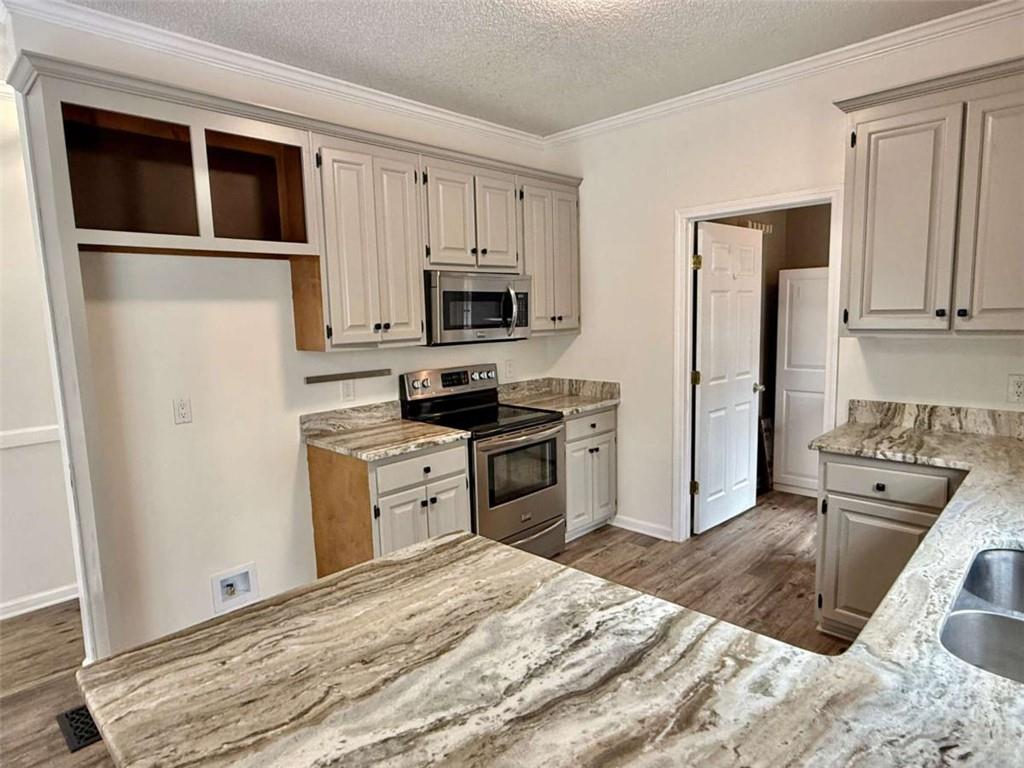 460 Rivers Road Fayetteville, GA 30214 - Photo 14 of 69 a kitchen with granite countertop a refrigerator stove and microwave