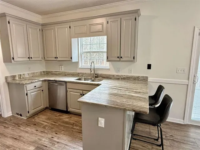 a view of a kitchen with a sink stove cabinets and empty room