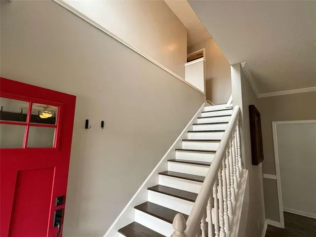 a view of an empty room with wooden floor and windows