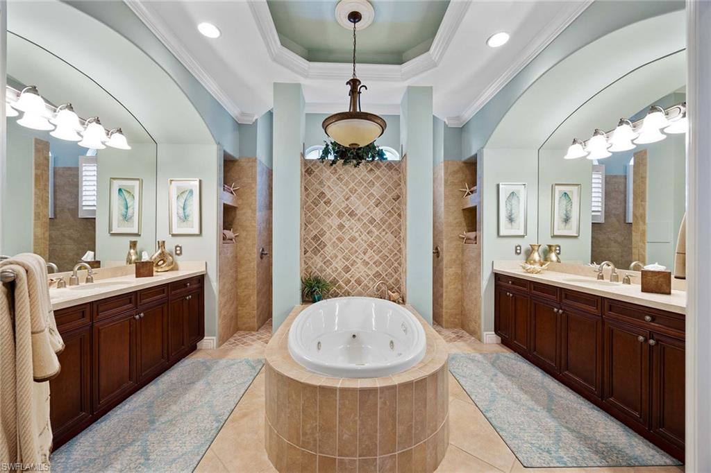 9038 Shenendoah Circle Naples, FL 34113 - Photo 16 of 50 a bathroom with a sink a large mirror and a shower