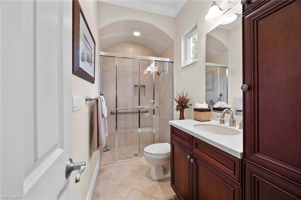 9038 Shenendoah Circle Naples, FL 34113 - Photo 25 of 50 a bathroom with a sink a toilet and a large mirror