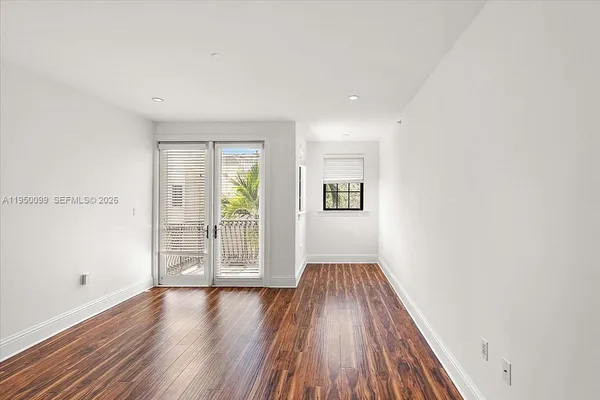 a view of a hallway with wooden floor and windows