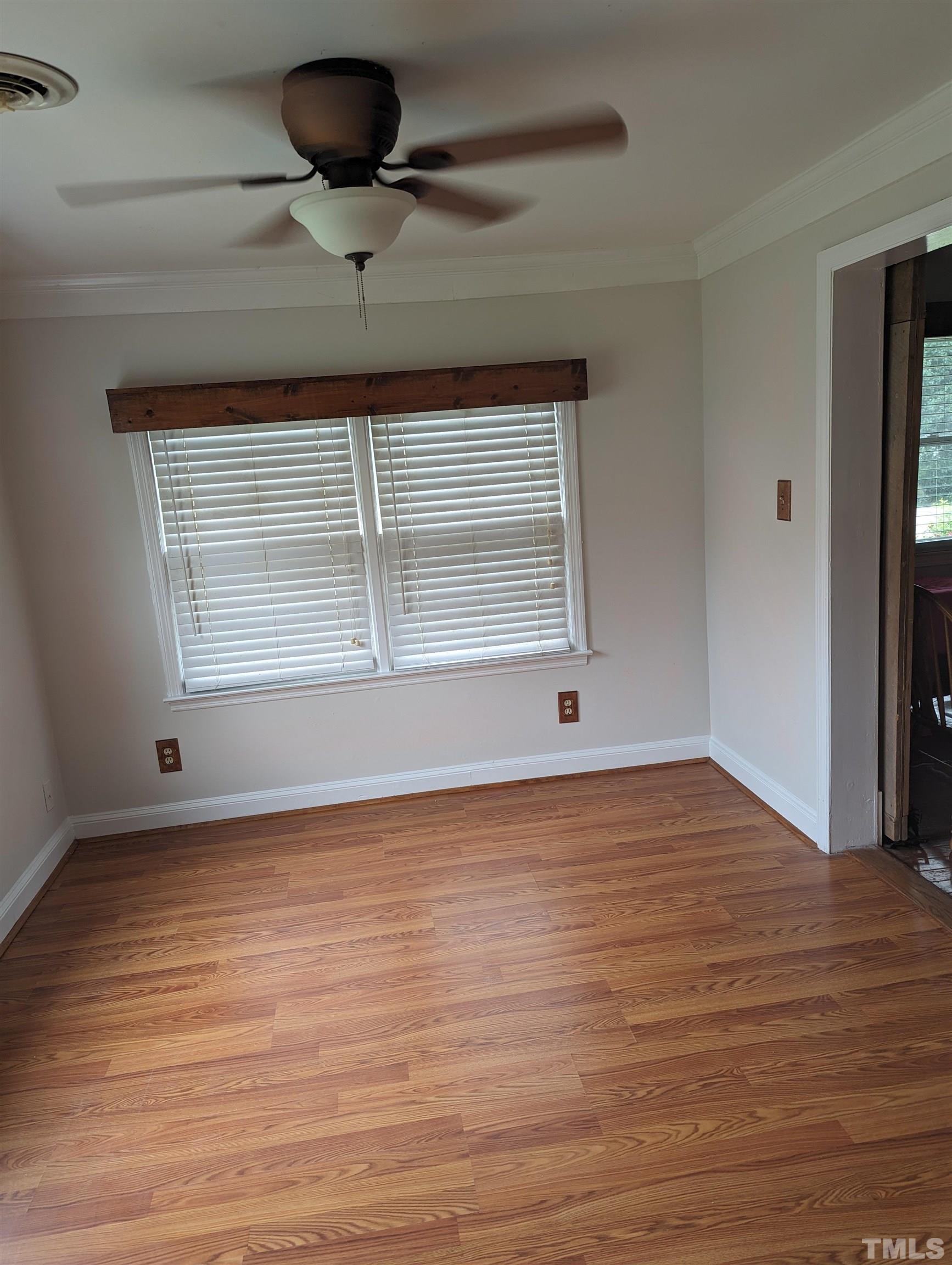 208 East Main Street Coats, NC 27521 - Photo 13 of 27 a view of an empty room with wooden floor and a window