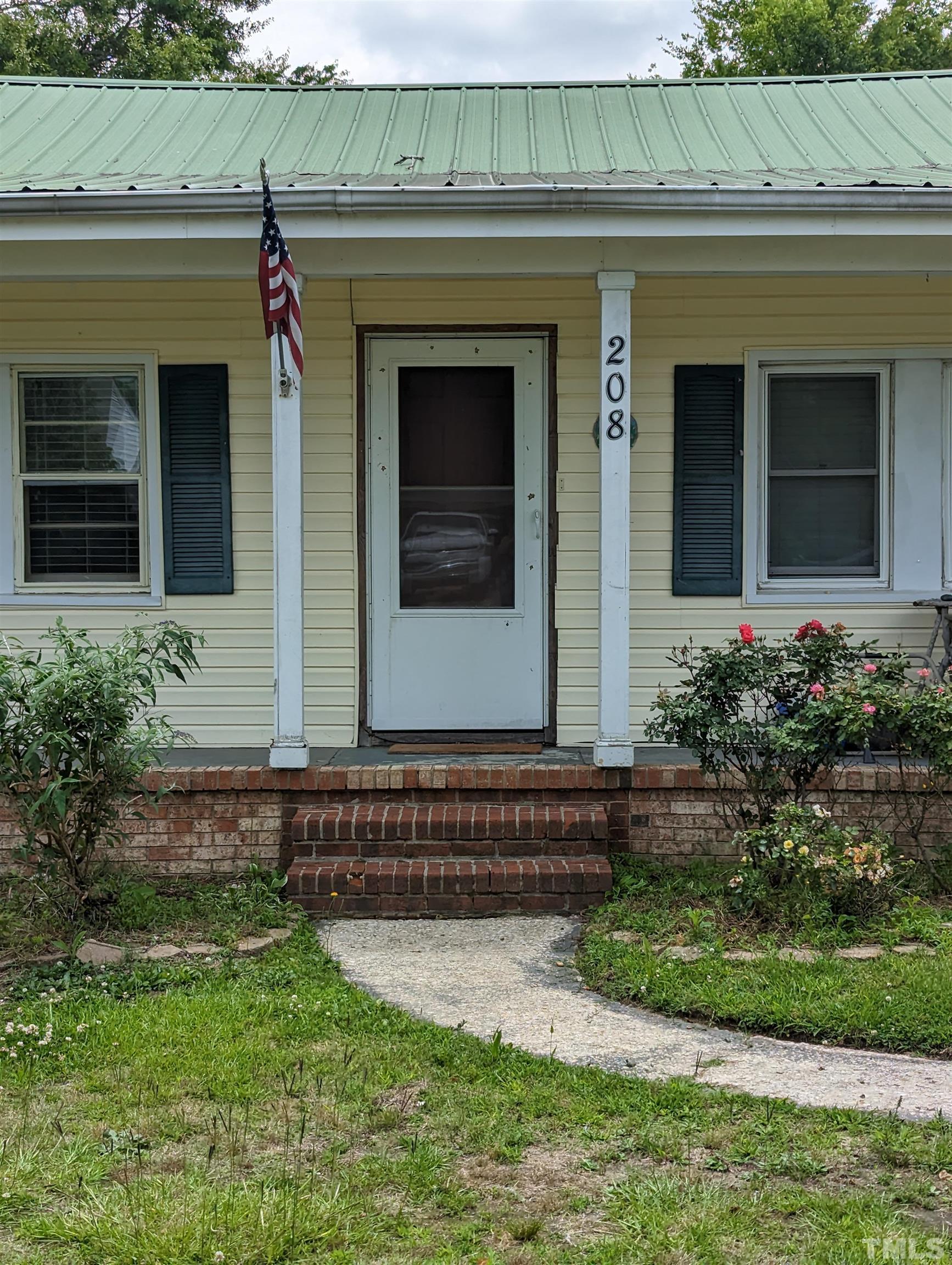208 East Main Street Coats, NC 27521 - Photo 2 of 27 a front view of a house with garden