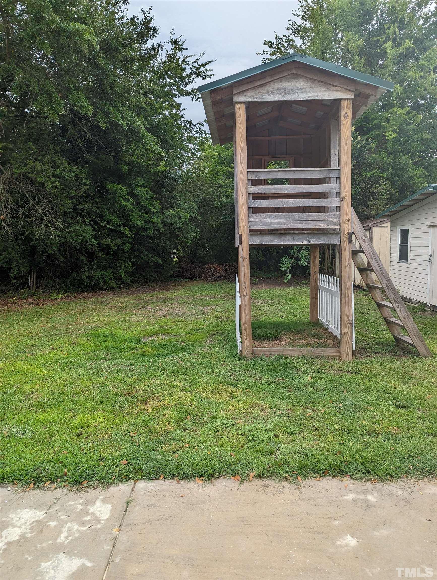 208 East Main Street Coats, NC 27521 - Photo 21 of 27 a backyard of a house with a garden and deck