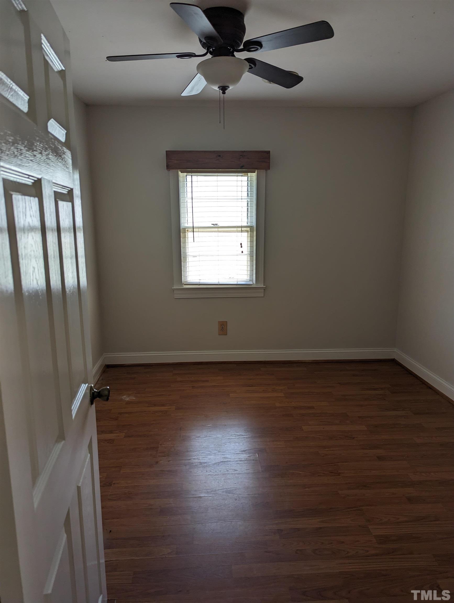 208 East Main Street Coats, NC 27521 - Photo 4 of 27 an empty room with wooden floor cabinet and windows
