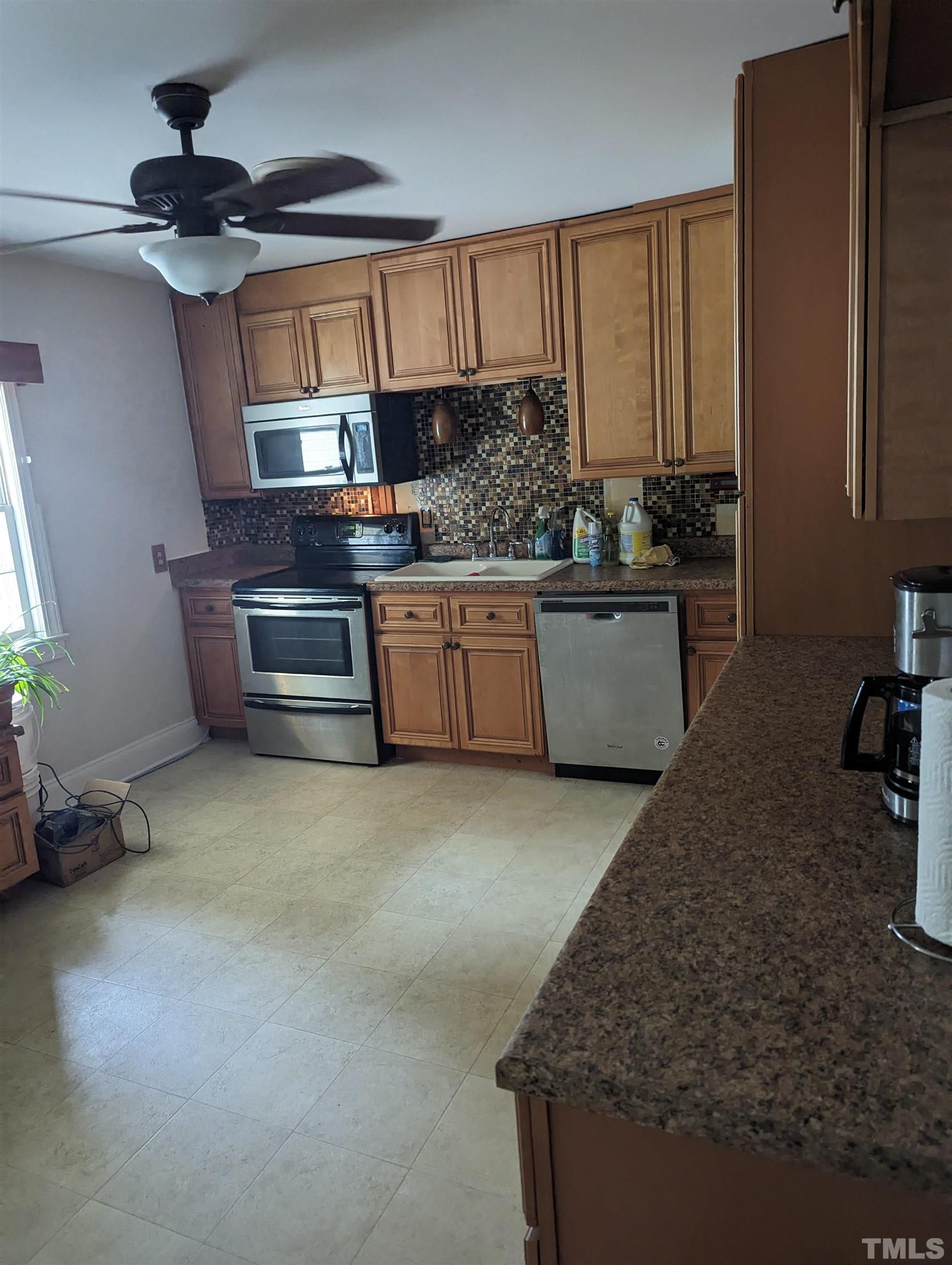 208 East Main Street Coats, NC 27521 - Photo 8 of 27 a kitchen with stainless steel appliances granite countertop a sink stove and cabinets