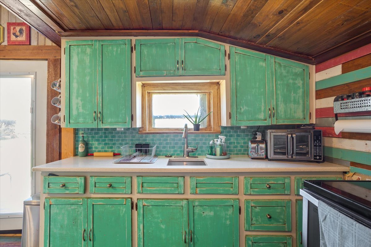 2804 Auction Barn Road Belton, TX 76513 - Photo 11 of 22 Kitchen featuring green cabinets, light countertops, and a vaulted wood ceiling