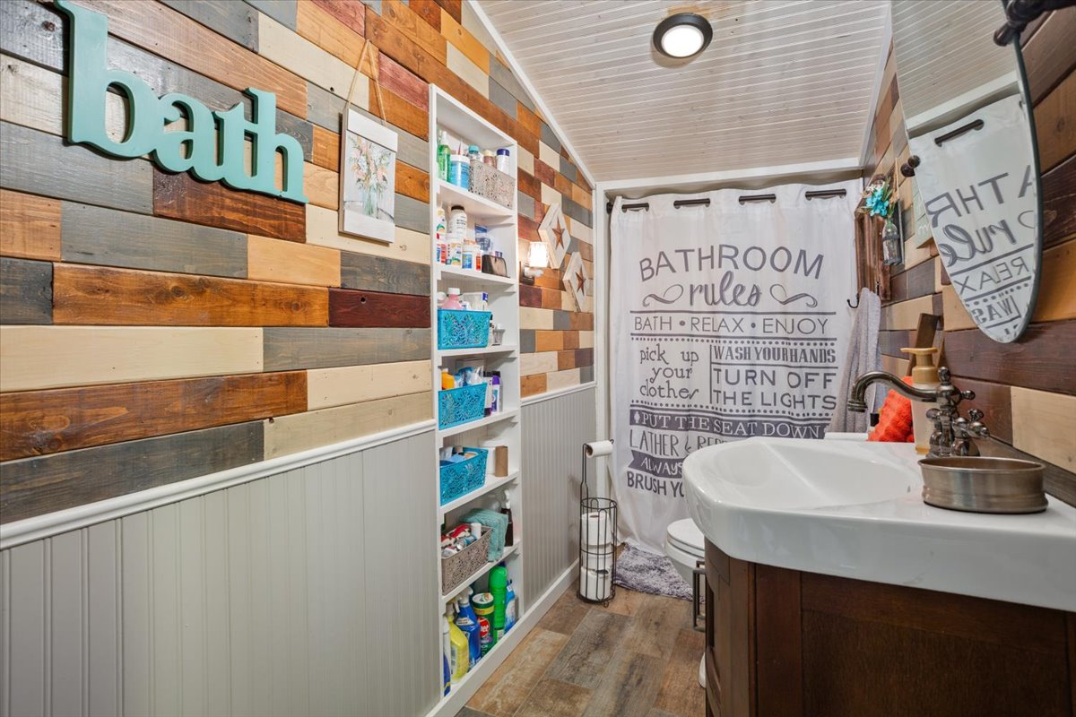 2804 Auction Barn Road Belton, TX 76513 - Photo 15 of 22 Bathroom featuring wood walls, vanity, dark wood-style flooring, and wood ceiling