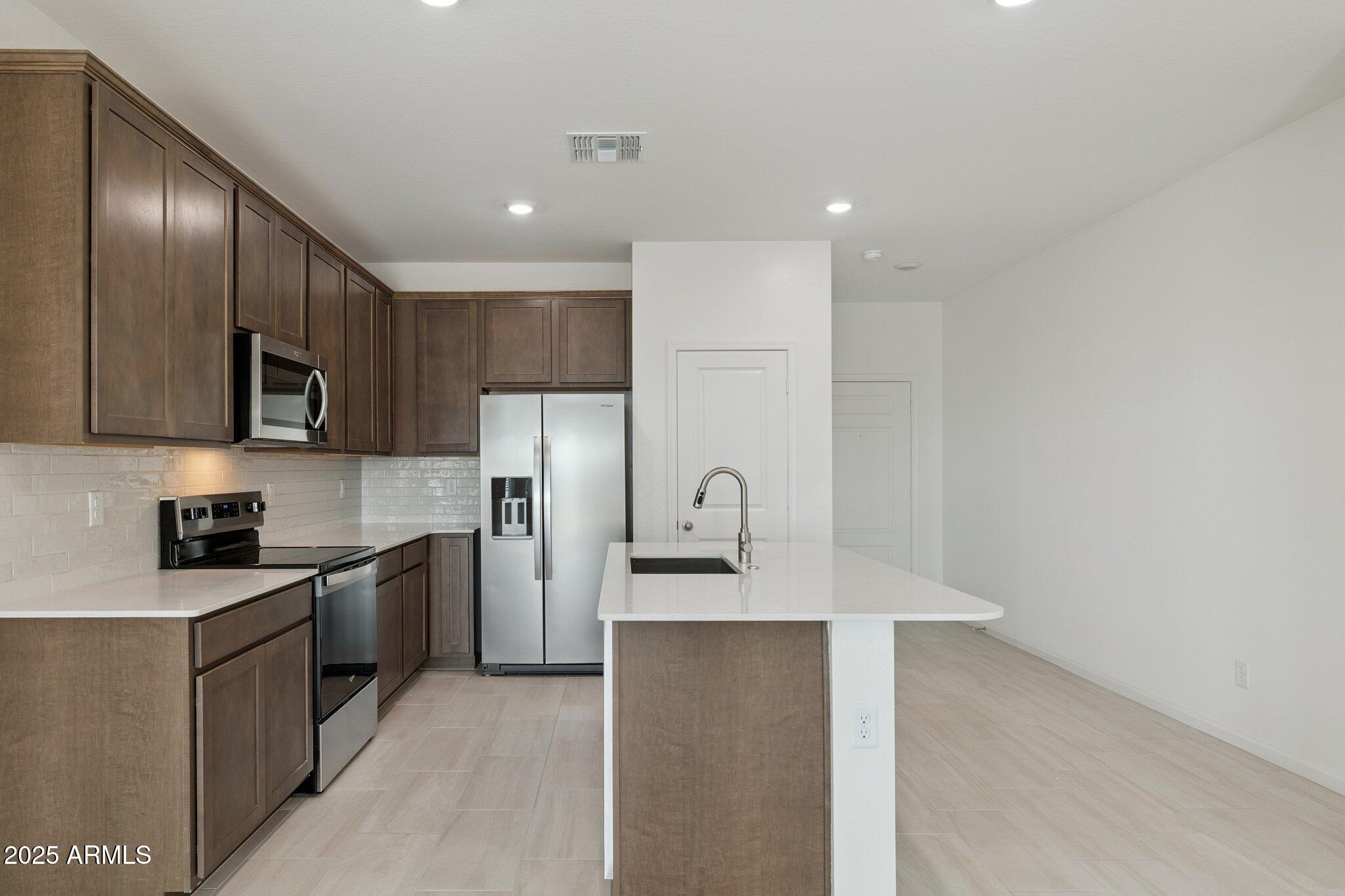 25471 West Fraktur Road Buckeye, AZ 85326 - Photo 5 of 17 a kitchen with stainless steel appliances granite countertop a refrigerator sink and stove
