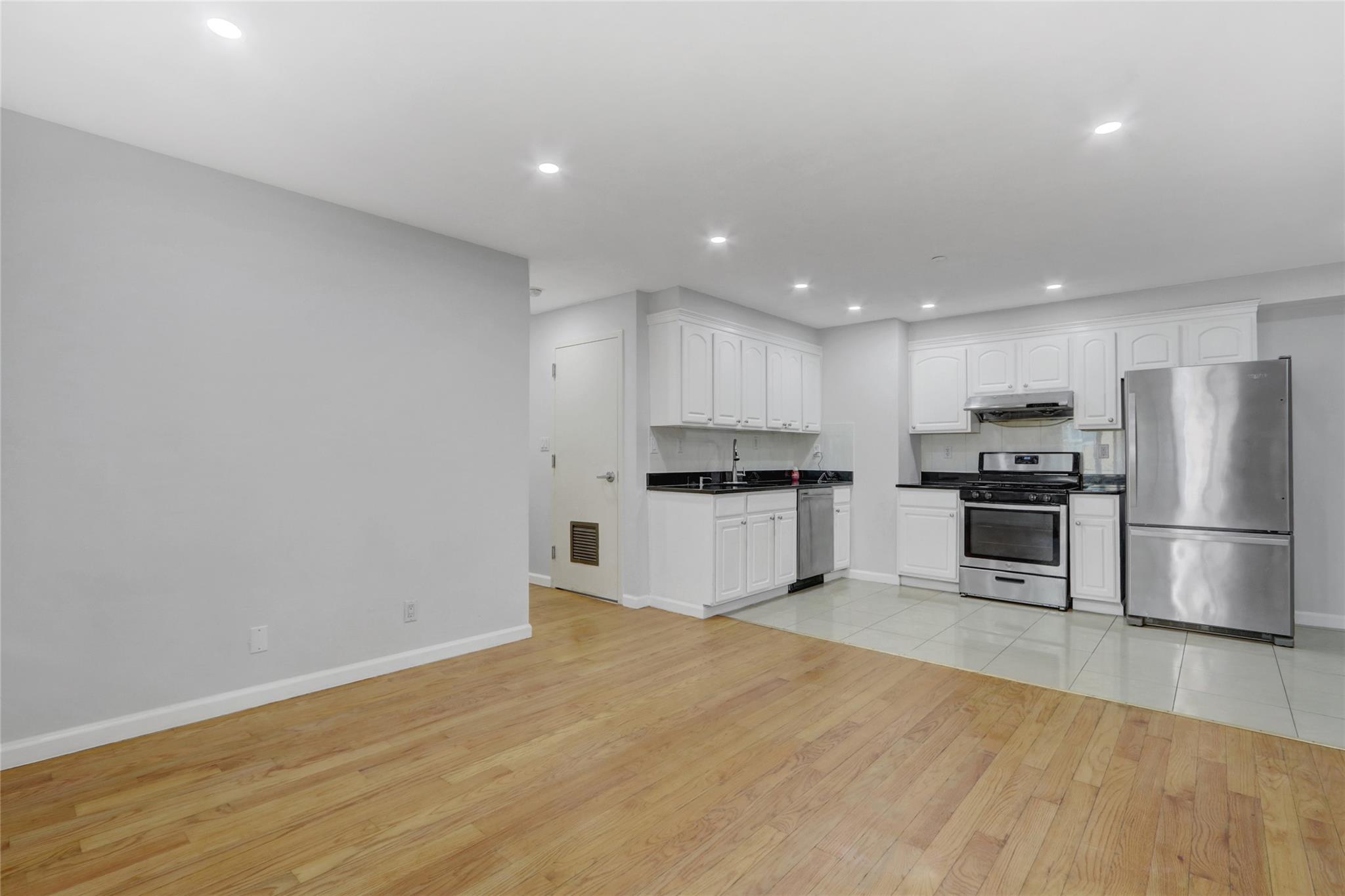 43-17 Union Street, Unit 5A Queens, NY 11355 - Photo 7 of 19 Kitchen featuring appliances with stainless steel finishes, light wood-type flooring, white cabinets, dark countertops, and recessed lighting