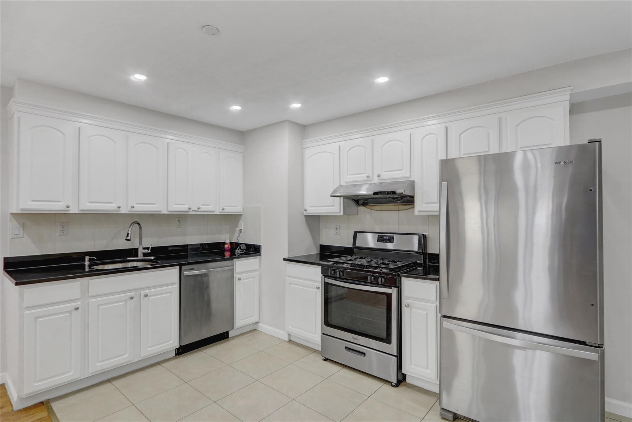43-17 Union Street, Unit 5A Queens, NY 11355 - Photo 10 of 19 Kitchen with stainless steel appliances, dark countertops, white cabinetry, under cabinet range hood, and recessed lighting