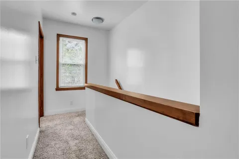 an empty room with a chandelier fan and windows