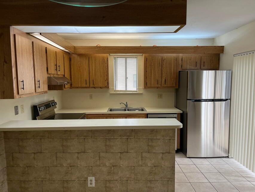 4803 Waterview Circle Palm Springs, FL 33461 - Photo 4 of 22 a kitchen with stainless steel appliances granite countertop a refrigerator sink and cabinets
