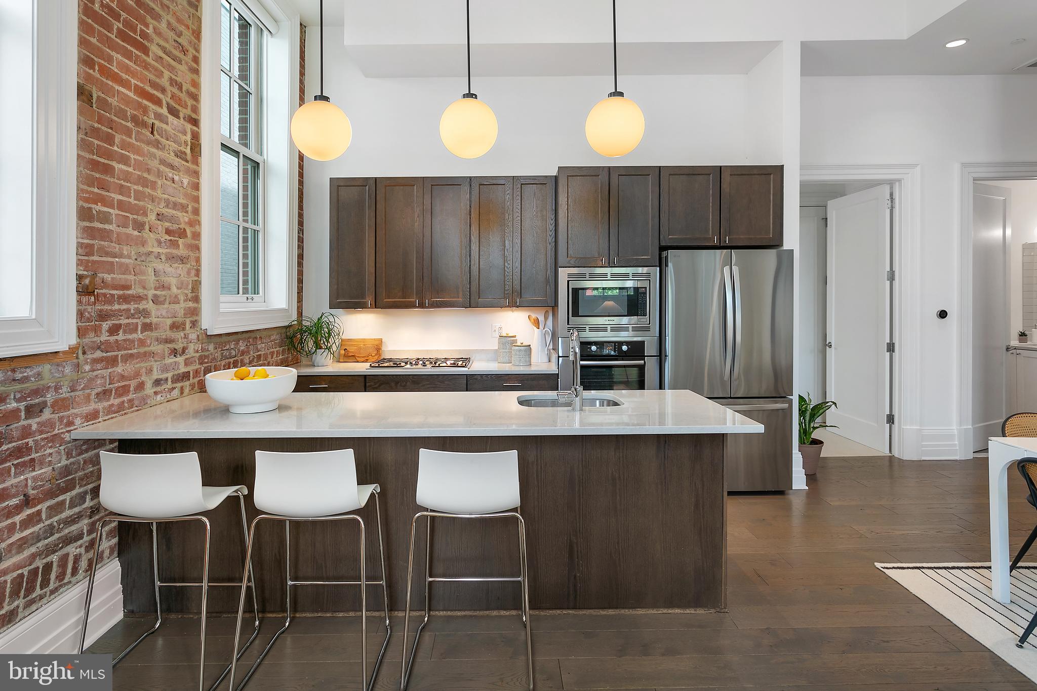 901 D Street Northeast, Unit 102 Washington, DC 20002 - Photo 11 of 40 a kitchen with a sink cabinets and wooden floor