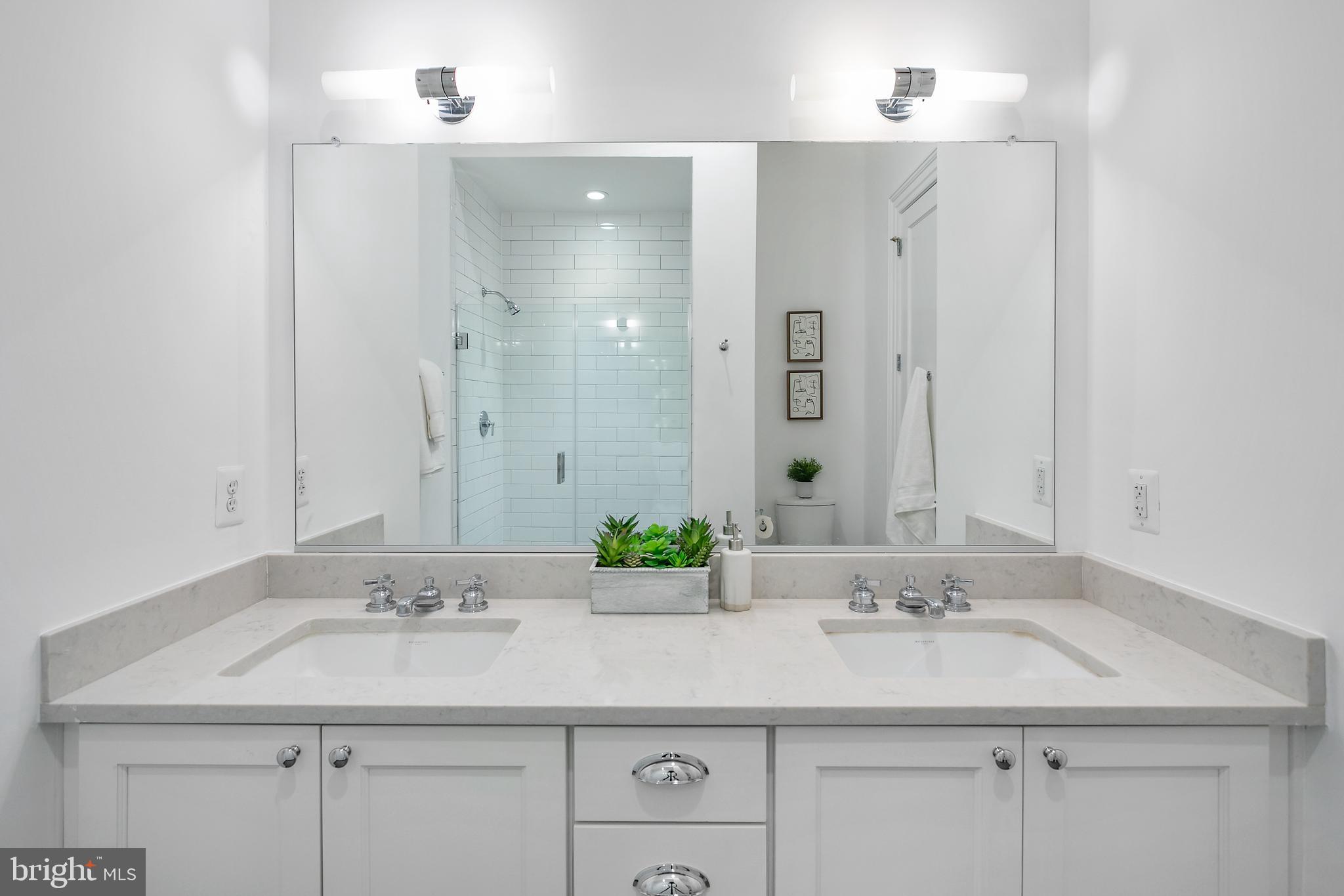 901 D Street Northeast, Unit 102 Washington, DC 20002 - Photo 22 of 40 a bathroom with a sink double vanity and a mirror