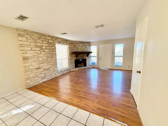a view of empty room with wooden floor and fireplace