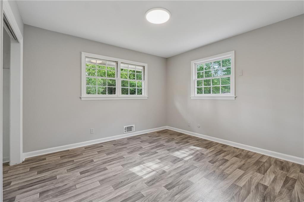 4616 Greensprings Road Atlanta, GA 30337 - Photo 14 of 26 a view of an empty room with wooden floor and a window