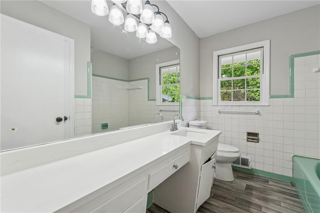 4616 Greensprings Road Atlanta, GA 30337 - Photo 16 of 26 a bathroom with a sink a large mirror and a bathtub