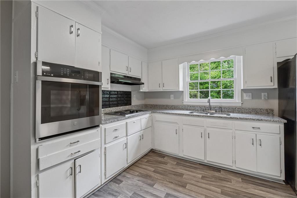 4616 Greensprings Road Atlanta, GA 30337 - Photo 10 of 26 a kitchen with stainless steel appliances granite countertop white cabinets a sink and a window