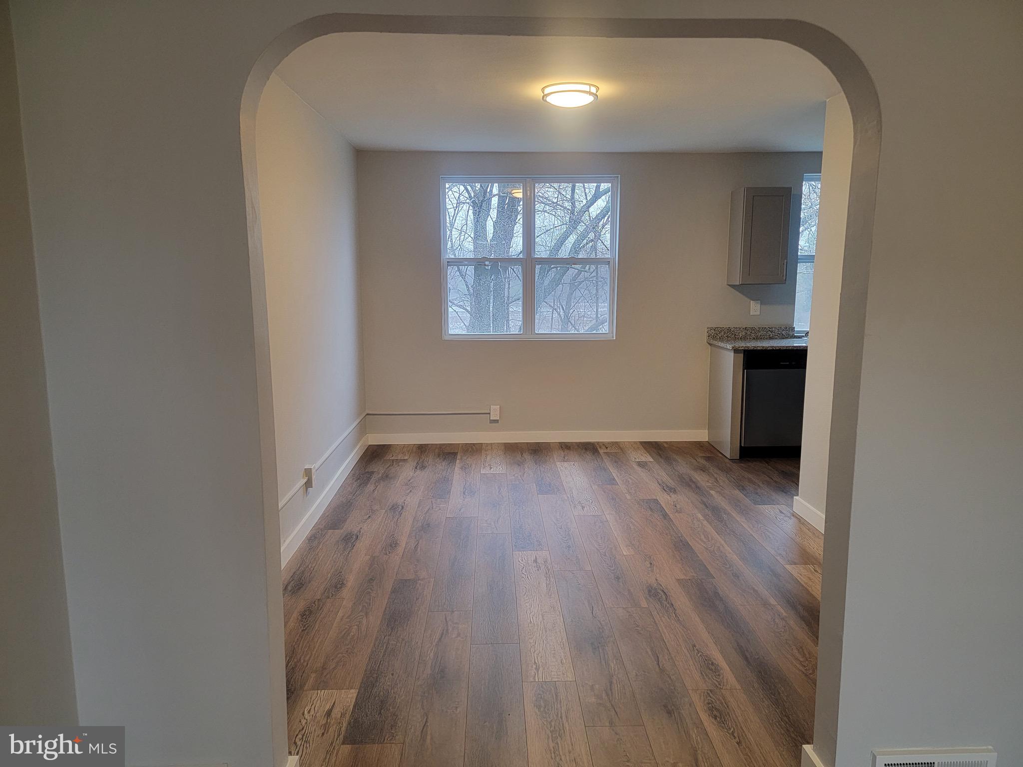 2896 Cushing Road Camden, NJ 08104 - Photo 3 of 31 an empty room with wooden floor and windows