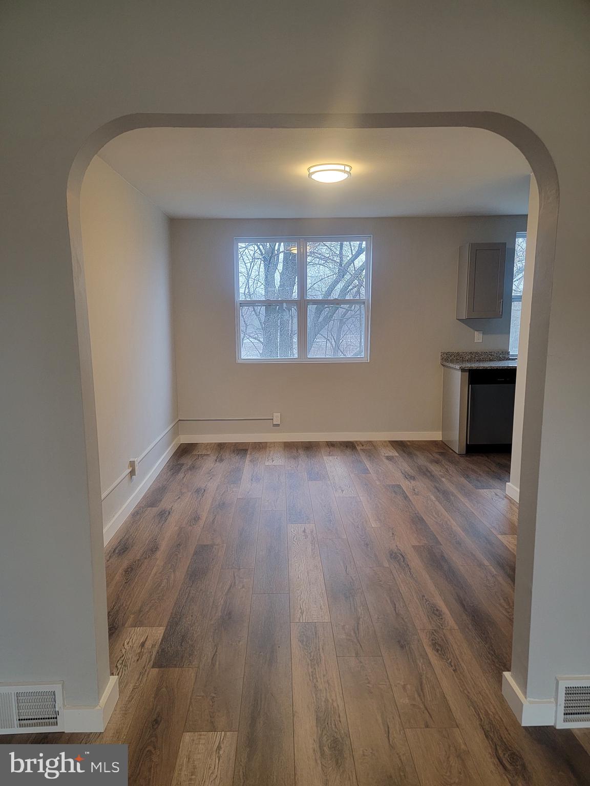 2896 Cushing Road Camden, NJ 08104 - Photo 4 of 31 an empty room with wooden floor and windows
