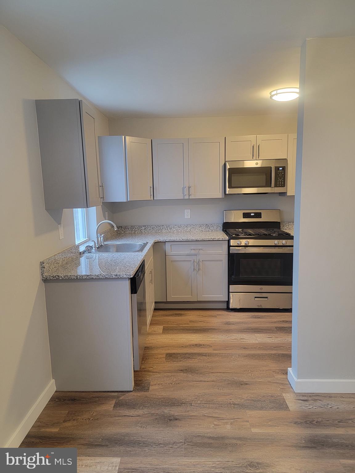 2896 Cushing Road Camden, NJ 08104 - Photo 5 of 31 a kitchen with stainless steel appliances granite countertop a stove a sink and a microwave
