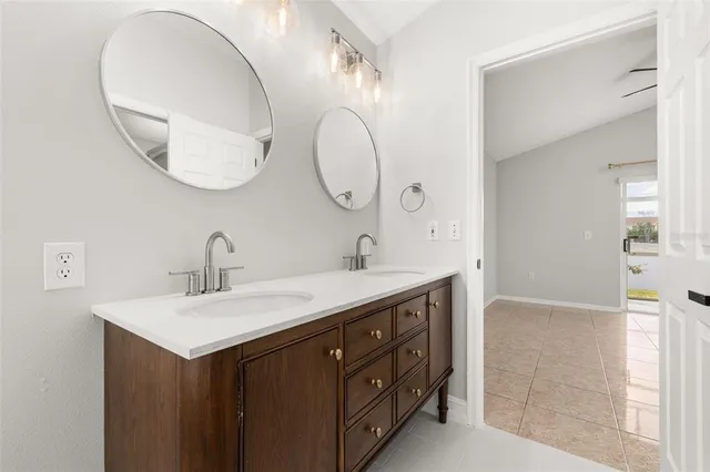 a view of an empty room with window and chandelier fan