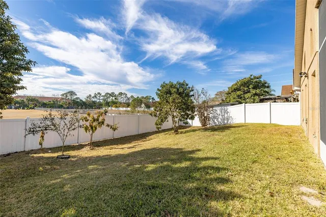 a view of an house with backyard and tree