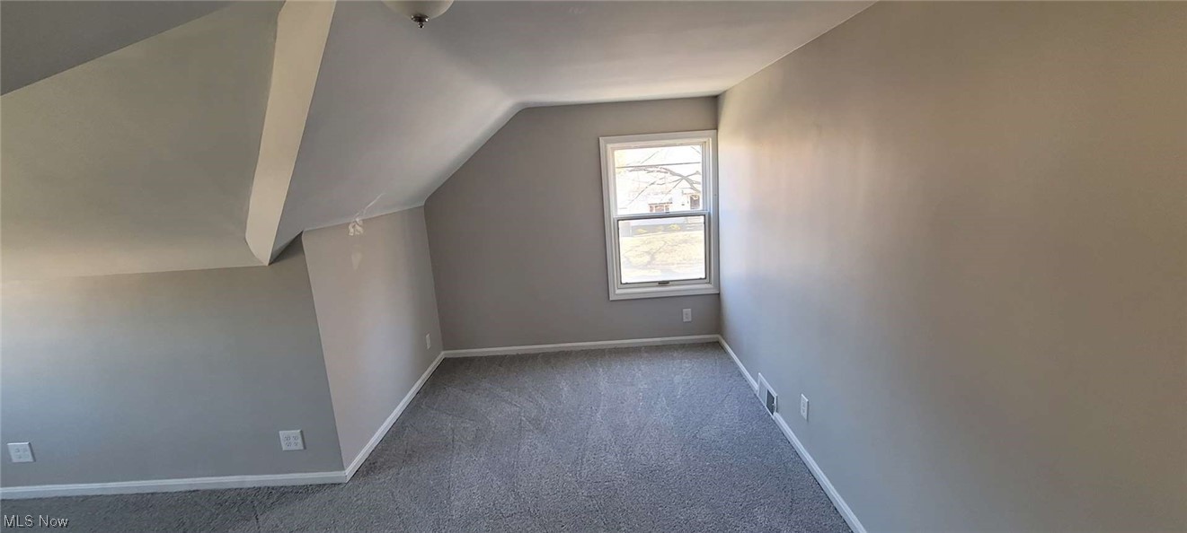 6149 North Canterbury Road Parma, OH 44129 - Photo 13 of 16 Additional living space featuring dark colored carpet and vaulted ceiling