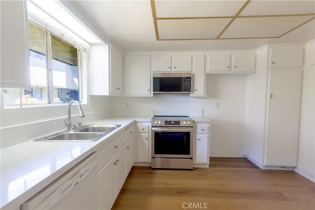 a kitchen with stainless steel appliances granite countertop a sink a stove a microwave and a refrigerator