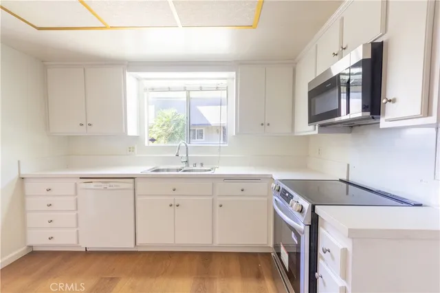 a kitchen with cabinets appliances a sink and a counter top space