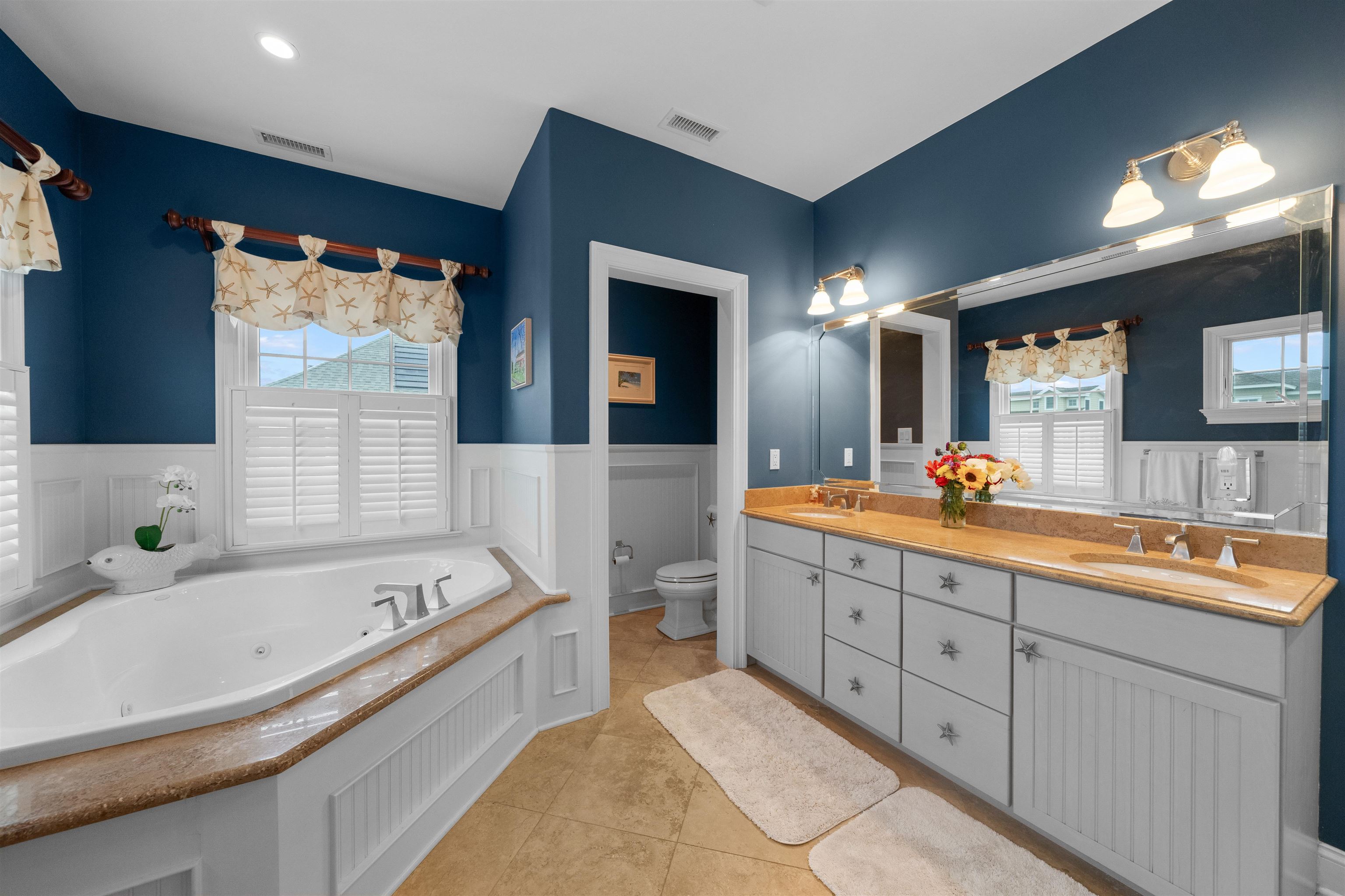 4765 4th Avalon, NJ 08202 - Photo 31 of 41 a bathroom with a bathtub double vanity sink and a large mirror