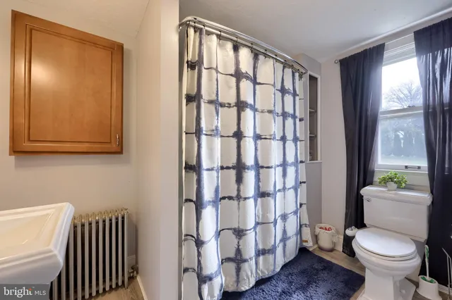 a bathroom with a toilet and a shower curtain