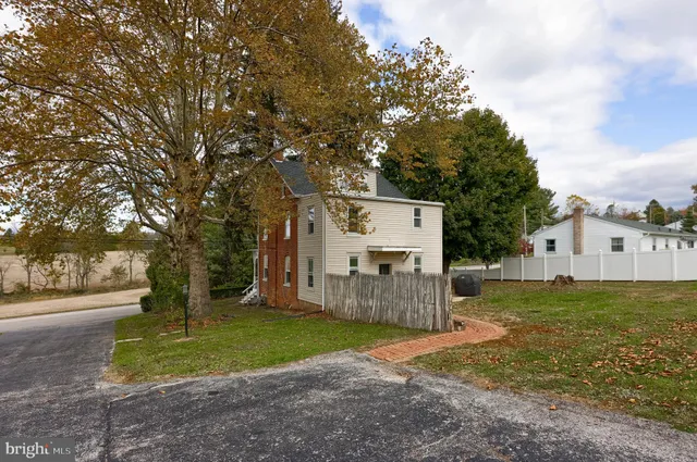 a view of a house with backyard and tree